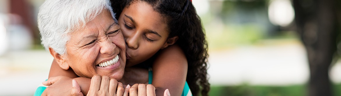 Senior woman being hugged by granddaughter