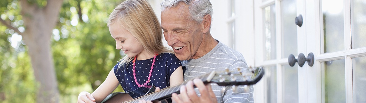 Resident playing guitar with granddaughter