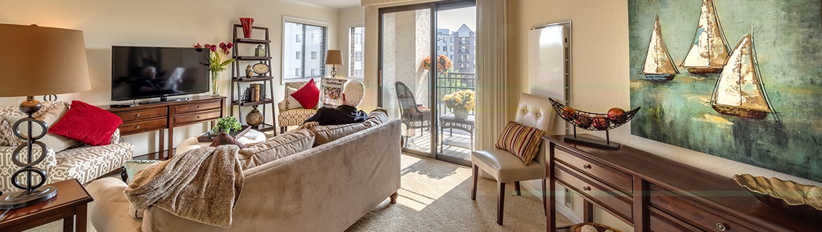 Resident sitting on couch of community apartment